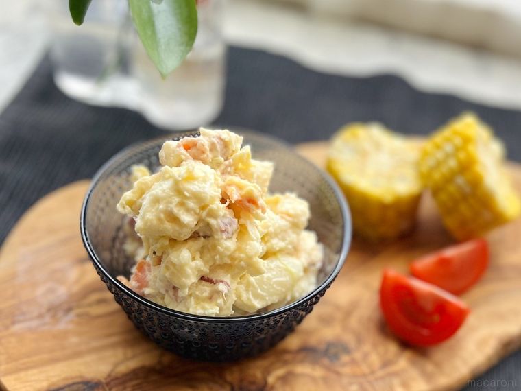 コストコの6種の具材のポテトサラダを器に盛り付けてトマトやコーンと一緒にウッドボードにのせたところ