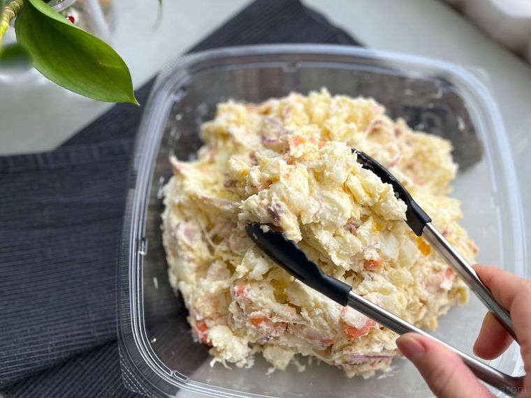 コストコの6種の具材のポテトサラダをトングで取り分けているところ