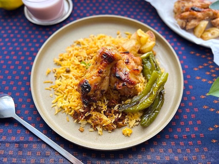 コストコのベジタブルビリヤニを皿に盛り、骨付きチキンや野菜をトッピングしたところ