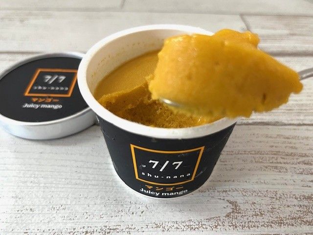 オレンジ色のマンゴーアイスを食べようとしている