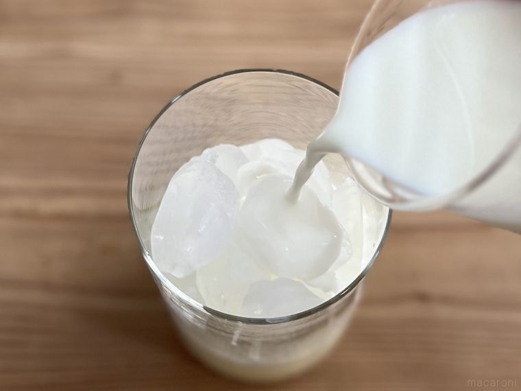 ヨーグルトや砂糖などが入った液体に牛乳をそそいでいる様子