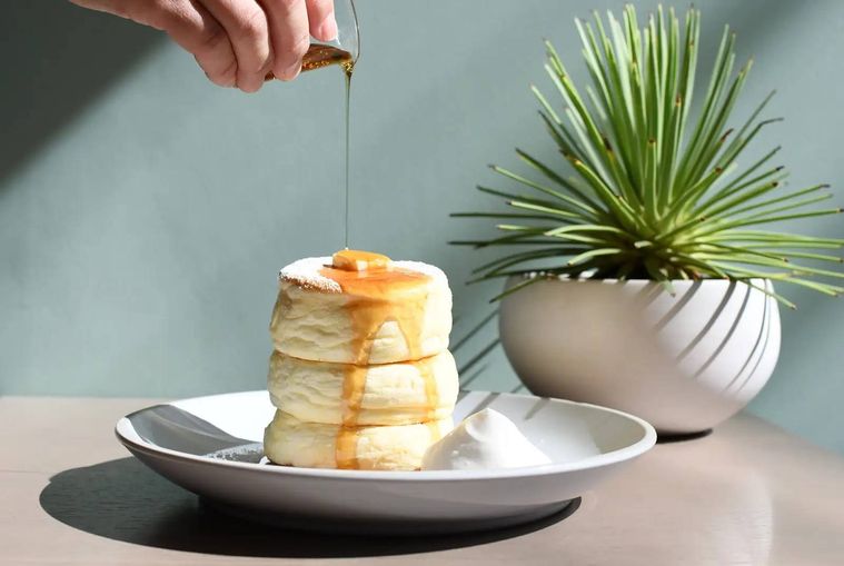 ミカサデコ ザ パークの ふわふわリコッタパンケーキにシロップをかける様子