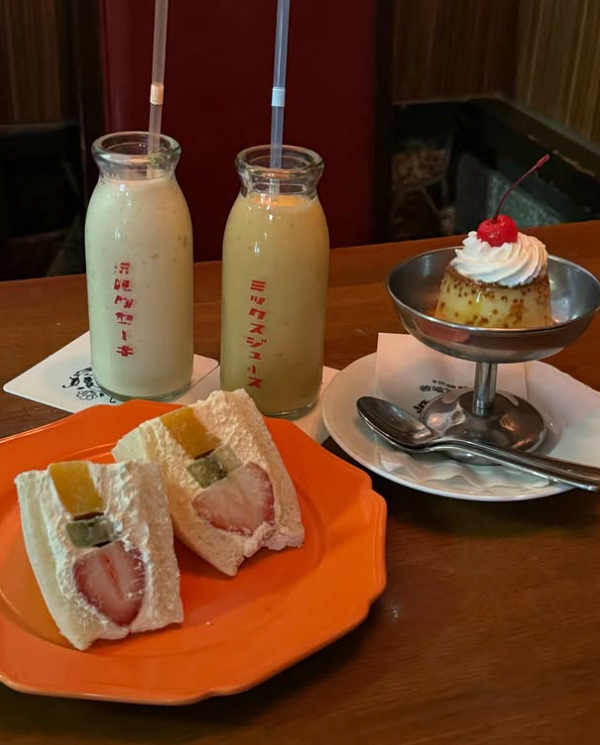 千成屋珈琲の瓶入りジュースやフルーツサンド、プリンをテーブルに並べた様子