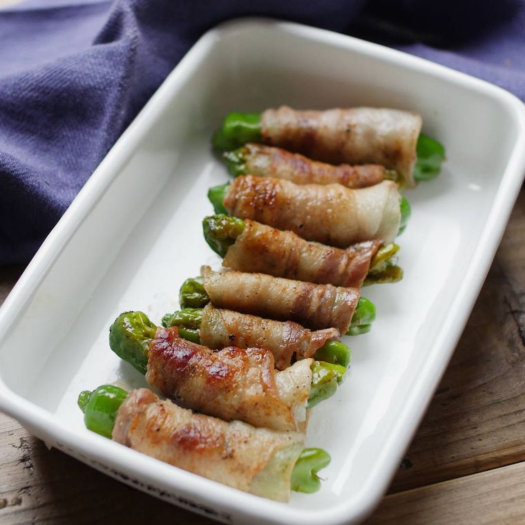 白い琺瑯容器に並べたししとうがらしの梅おかか豚肉巻き