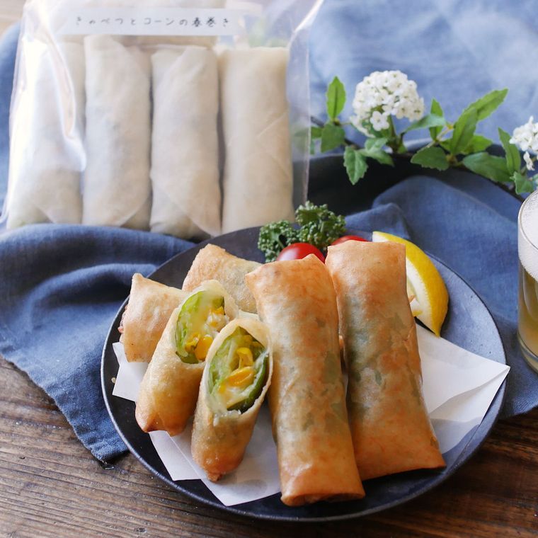 黒い皿に盛り付けたコーンとキャベツのチーズ春巻き