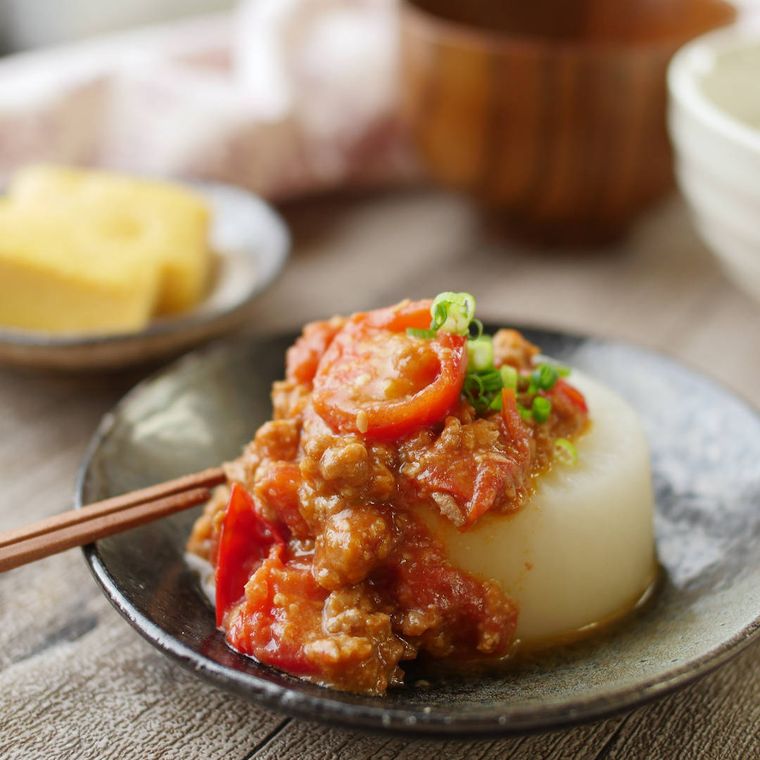 黒い小皿にのったトマトみそのふろふき大根