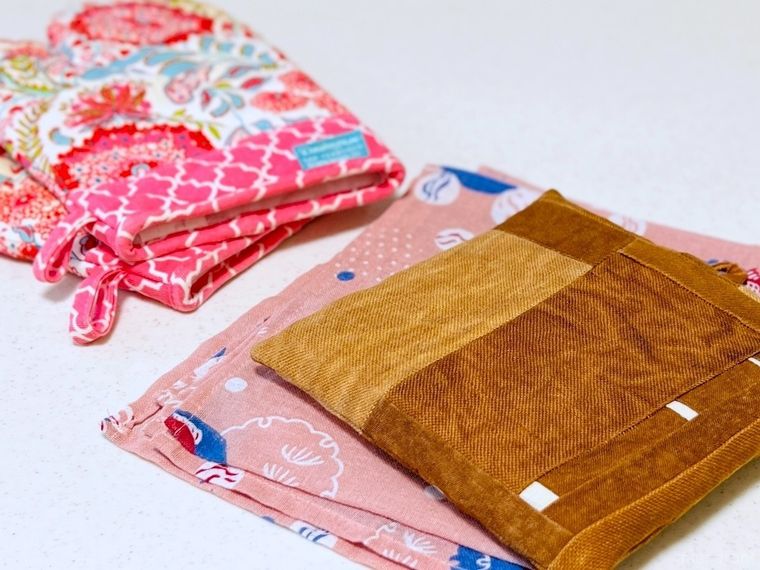 キッチンの調理台に鍋つかみ、手ぬぐい、鍋敷きが置かれている