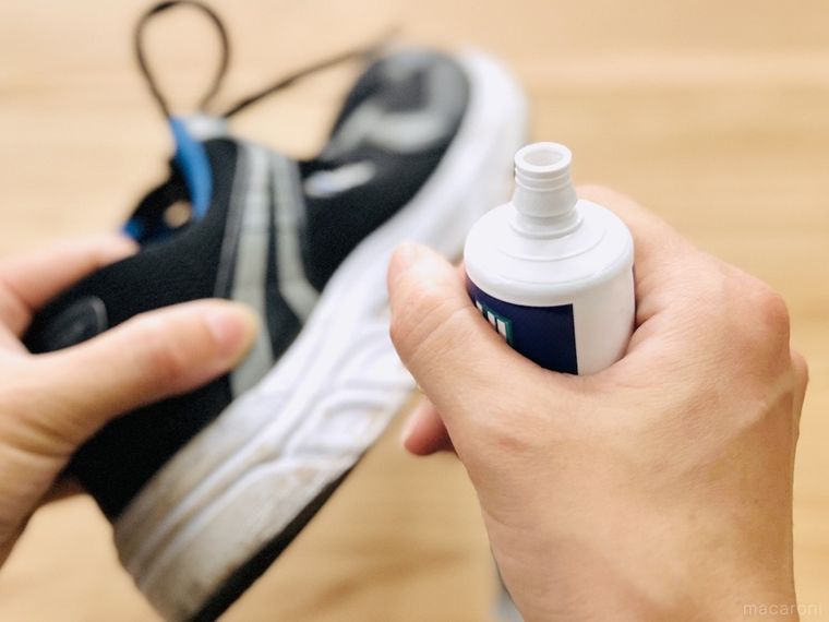 スニーカーと歯磨き粉を手で持っている様子