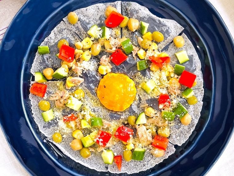 卵黄をのせて揚げたライスペーパーに具材をトッピングしたサラダ