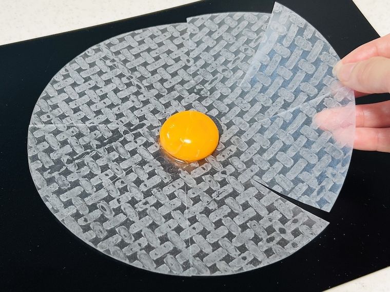 切り込みを入れたライスペーパーに卵黄をのせた様子