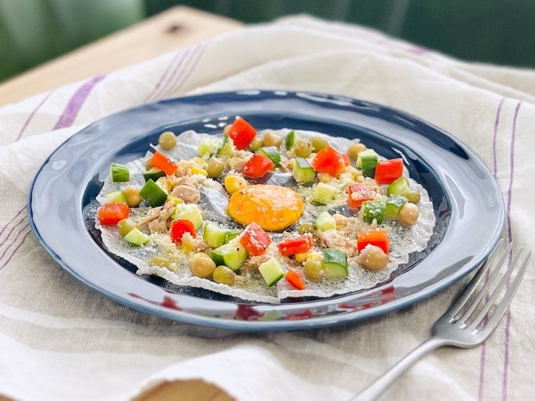 卵黄をのせて揚げたライスペーパーに具材をトッピングしたサラダ