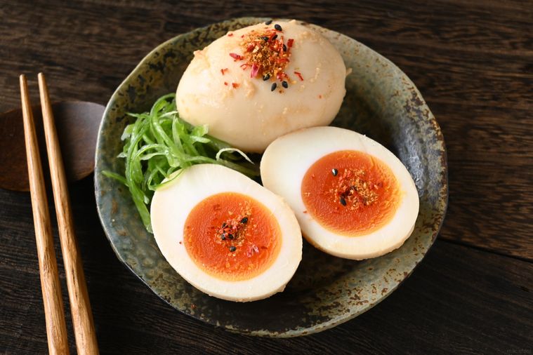 半分にカットしたみそ味玉とまるのままのみそ味玉が皿に盛り付けてある