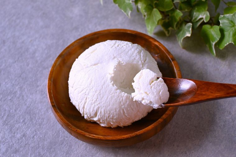 自家製クリームチーズを木のスプーンですくう様子