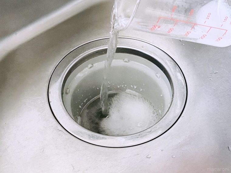 お湯で溶かしたクエン酸を排水口にそそいでいる様子