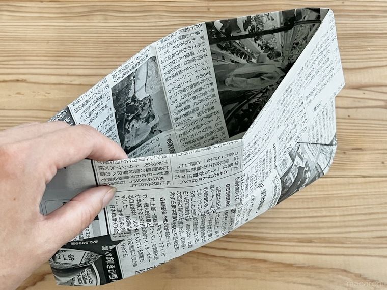 新聞紙で作った袋を手で持っている様子