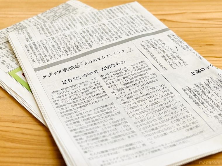 木のテーブルの上に新聞紙が置かれている様子