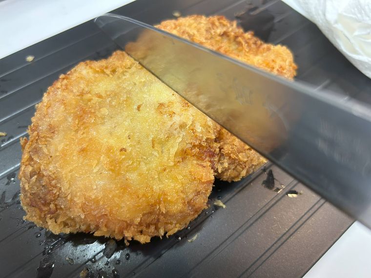 包丁でとんかつを切っている様子