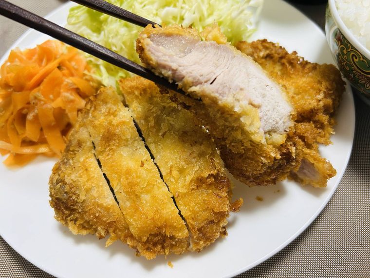 とんかつを箸で持ち上げる様子