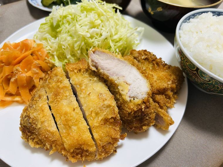 白い皿に盛り付けたとんかつと千切りキャベツ