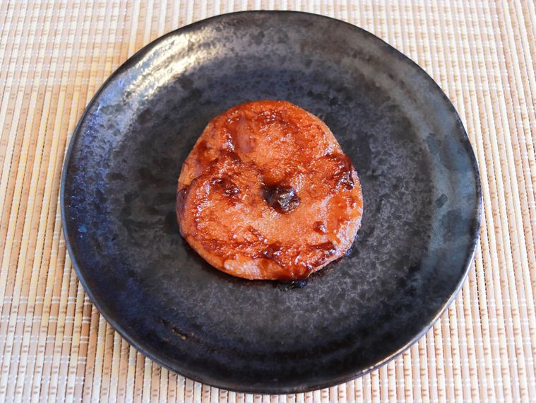 黒いお皿にのせた焼いたもっちゅりん みたらし