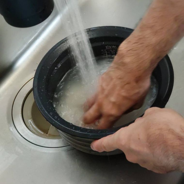 ほぼ透明になった研ぎ汁が入っている炊飯釜