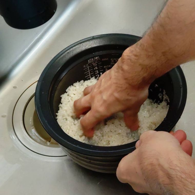 炊飯釜に入った米を研いでいる様子