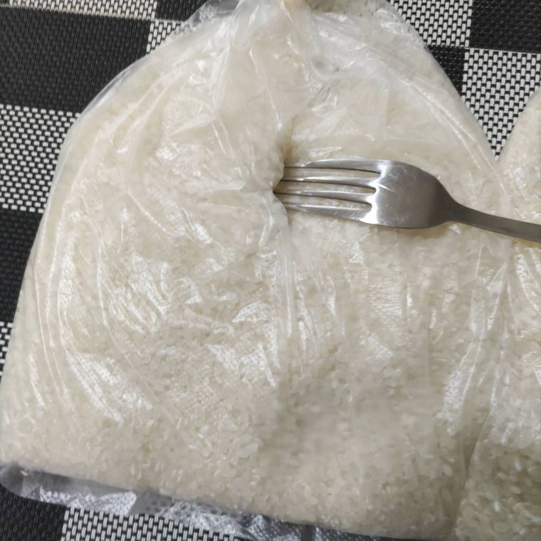 米が入った袋にフォークで穴を開けている様子