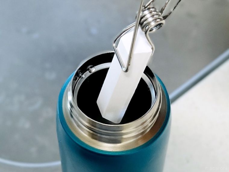 ピンチで挟んだ珪藻土スティックを水筒に入れようとしている様子