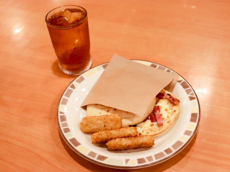 木製のテーブルの上にパンチェッタとチーズのパニーニ セットが置いてある