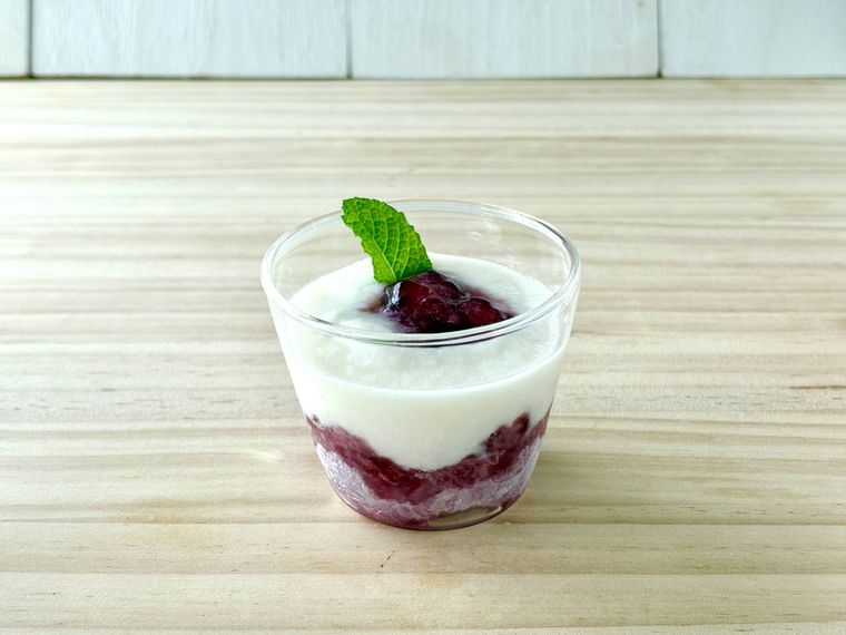 透明カップに重ねた凍らせたグレープゼリーとフルーチェヨーグルトの2層デザート。ミントを添えて涼しげに仕上げた様子。