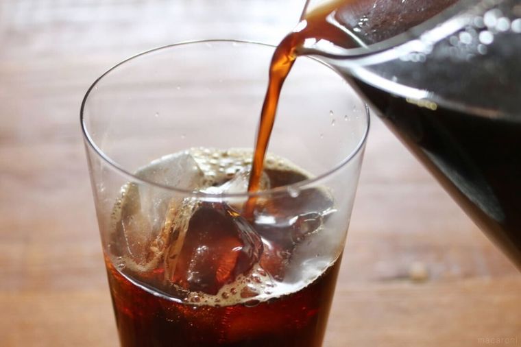 氷入りのグラスにコーヒーを注いでいる