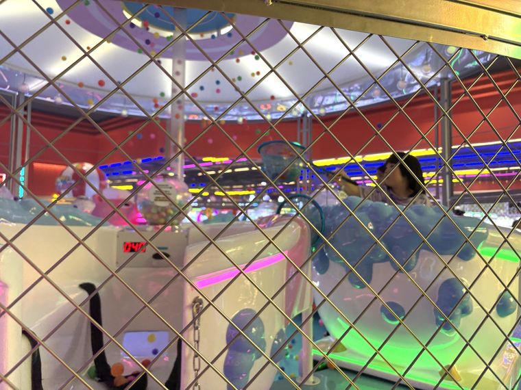 ピンポン玉を竿でキャッチして遊ぶ子ども