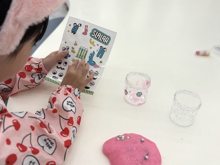 スララのシールを剥がしてオリジナルカップを制作している子ども