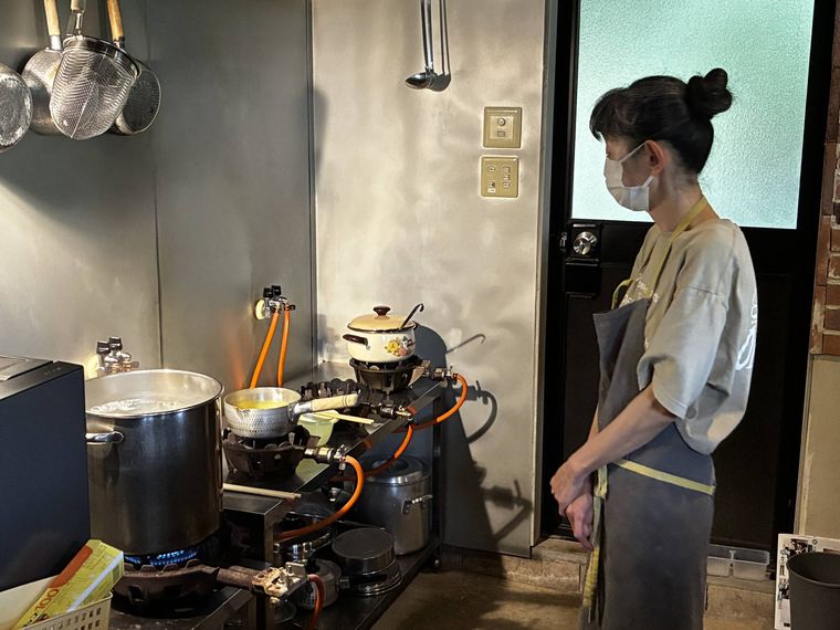 調理している鍋を見つめる店主