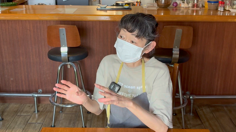 身振り手振りを交えて説明する店主