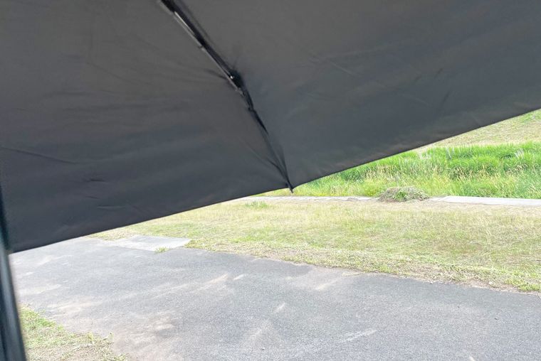 屋外でダイソーの日傘を差している写真
