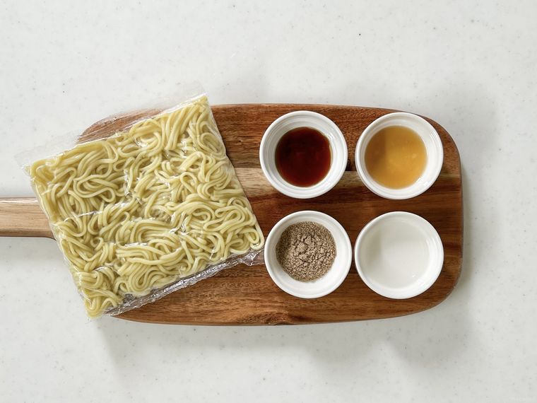 木製のお盆にのった焼きそば、焼きそばの粉、ごま油、オイスターソース、マヨネーズ、からし