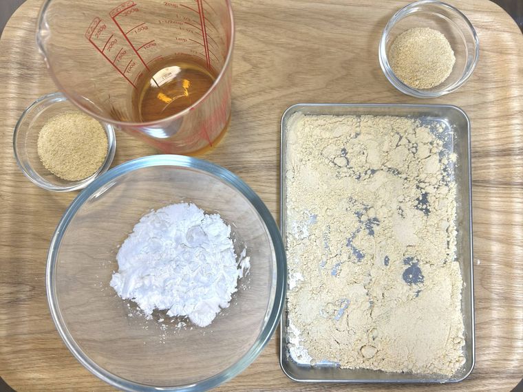 ガラスの容器に入った片栗粉とてんさい糖、ほうじ茶に、銀のバットのきな粉