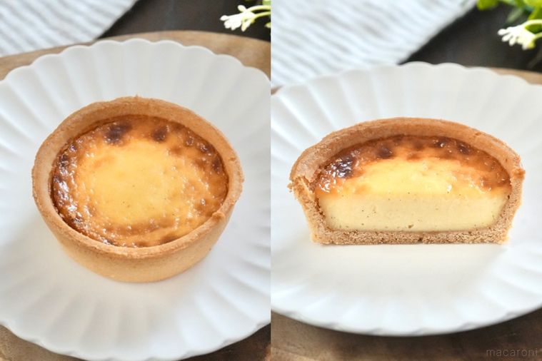 木のカッティングボードと白い皿にのったカスタードタルトとストライプの布とグリーン