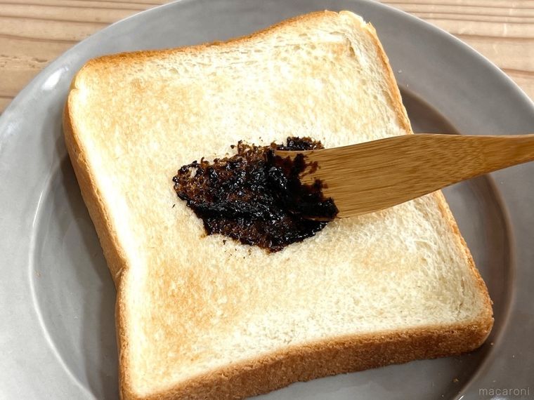 トーストの中央に海苔の佃煮を塗っている様子