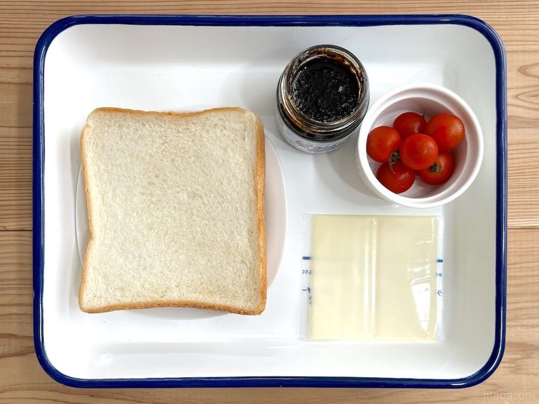 バットの上に食パン、海苔の佃煮、ミニトマト、スライスチーズが並んでいる