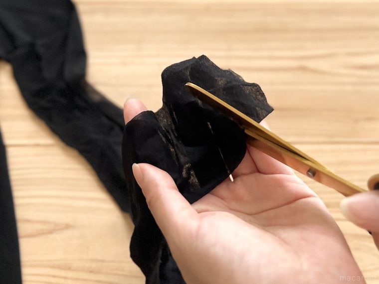 黒いストッキングをハサミで輪切りにしている様子