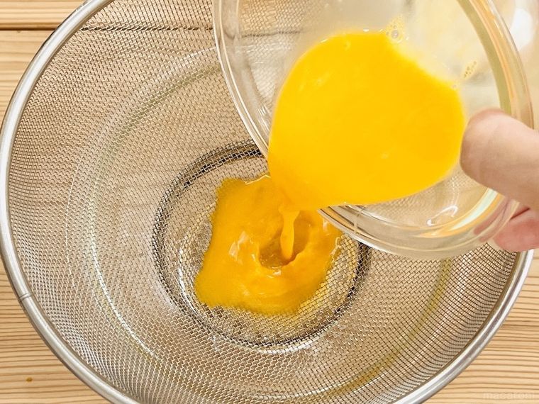 卵液をザルで濾している様子