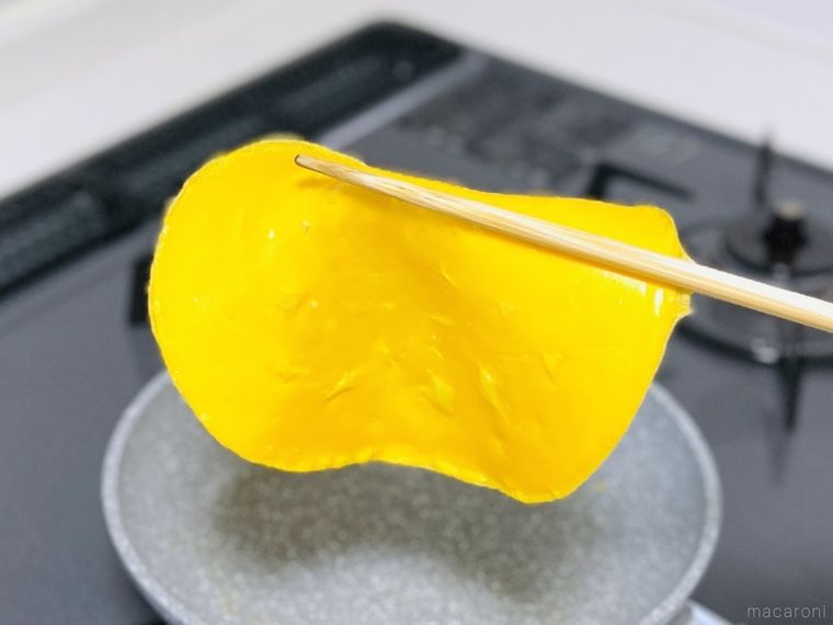 薄焼き卵を菜箸で持ち上げている様子