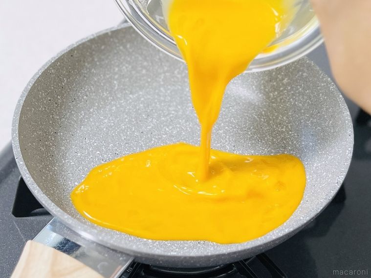 フライパンに卵液を流し入れている様子