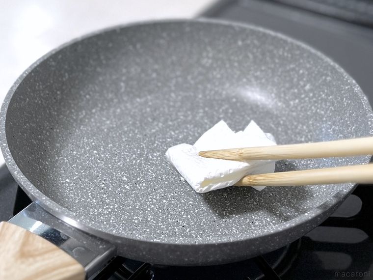 キッチンペーパーでフライパンにサラダ油を塗っている様子