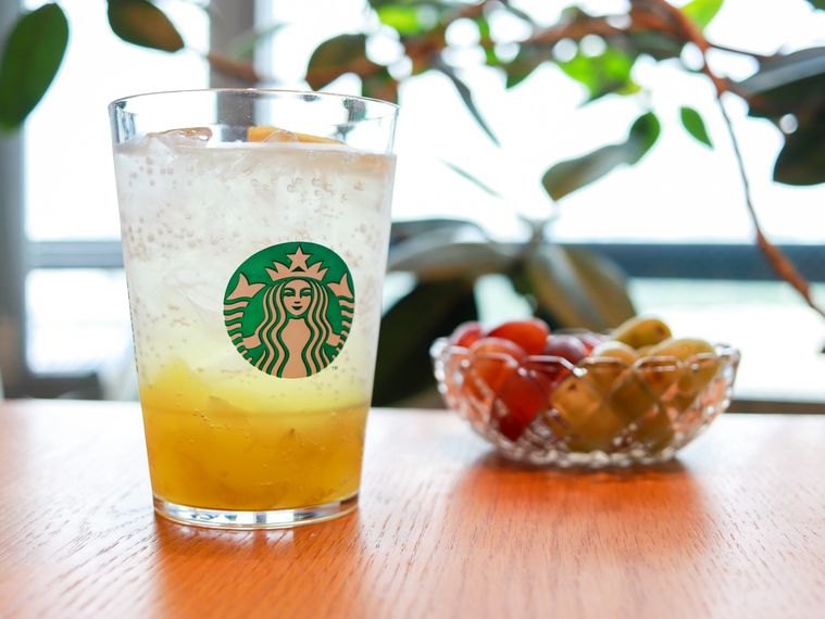 木製のテーブルの上にチラックス ソーダ マスカットとお皿に入ったマスカットが置かれている