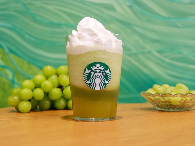 木製のテーブルの上にグラン マスカット フラペチーノとマスカットが置かれている