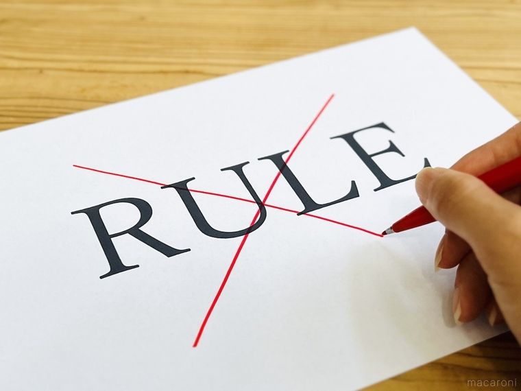 「RULE」と書かれた紙に赤いペンでバツ印を付けている様子