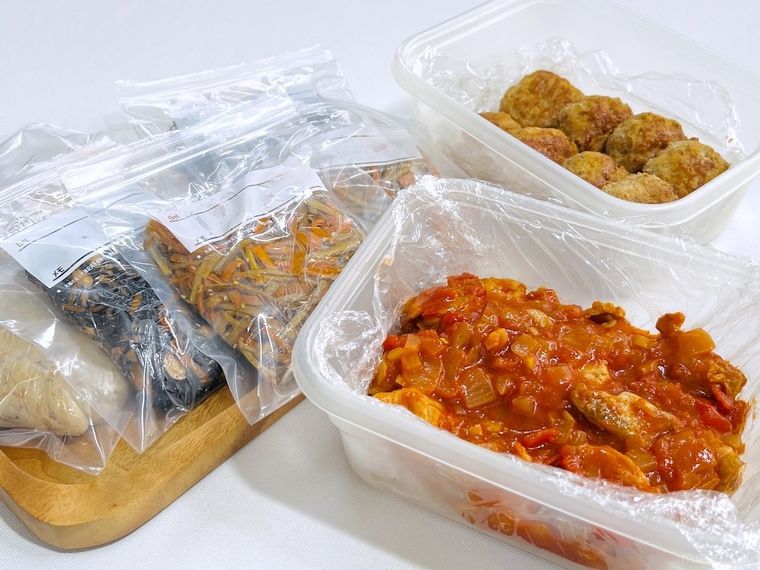 つくね、チキンのトマト煮込み、おからの煮物、ひじきの煮物、きんぴらごぼうを保存容器や保存袋に入れた様子